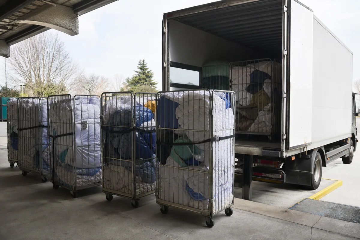 Rolls conteneurs remplis de linge sur le quai d&rsquo;une blanchisserie industrielle
